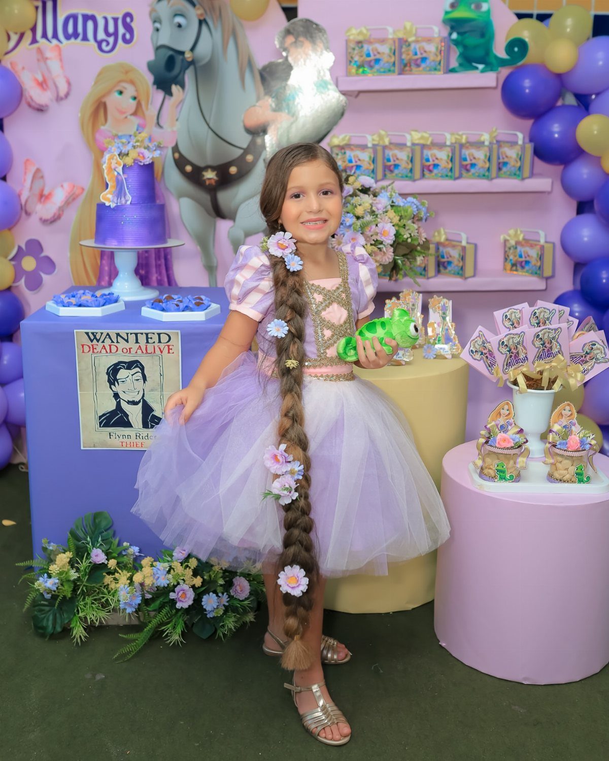 Girl in Rapunzel costume with long braided hair at a themed birthday party
