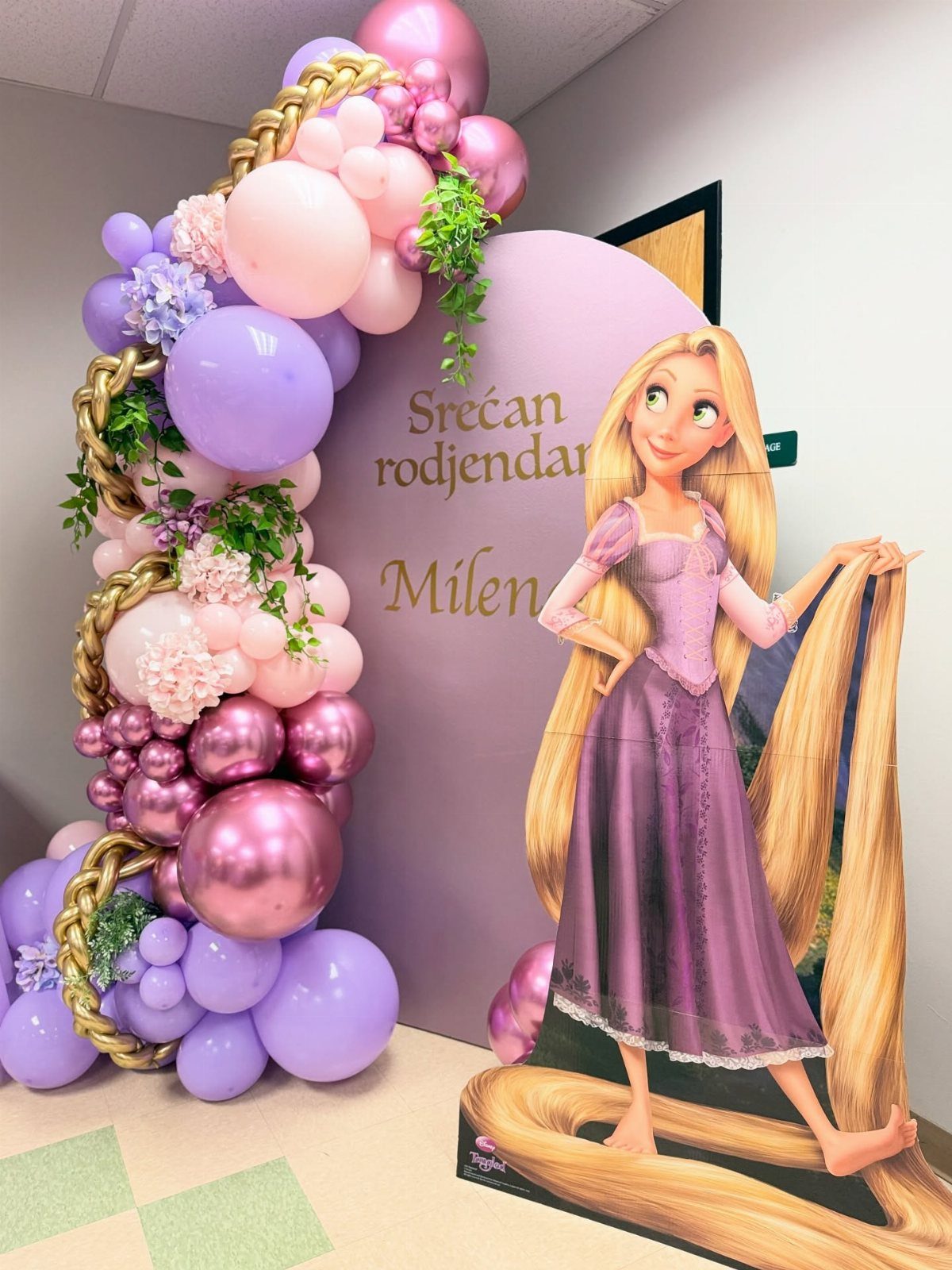 Balloon arch with braided gold rope and Rapunzel cardboard cutout for a birthday party