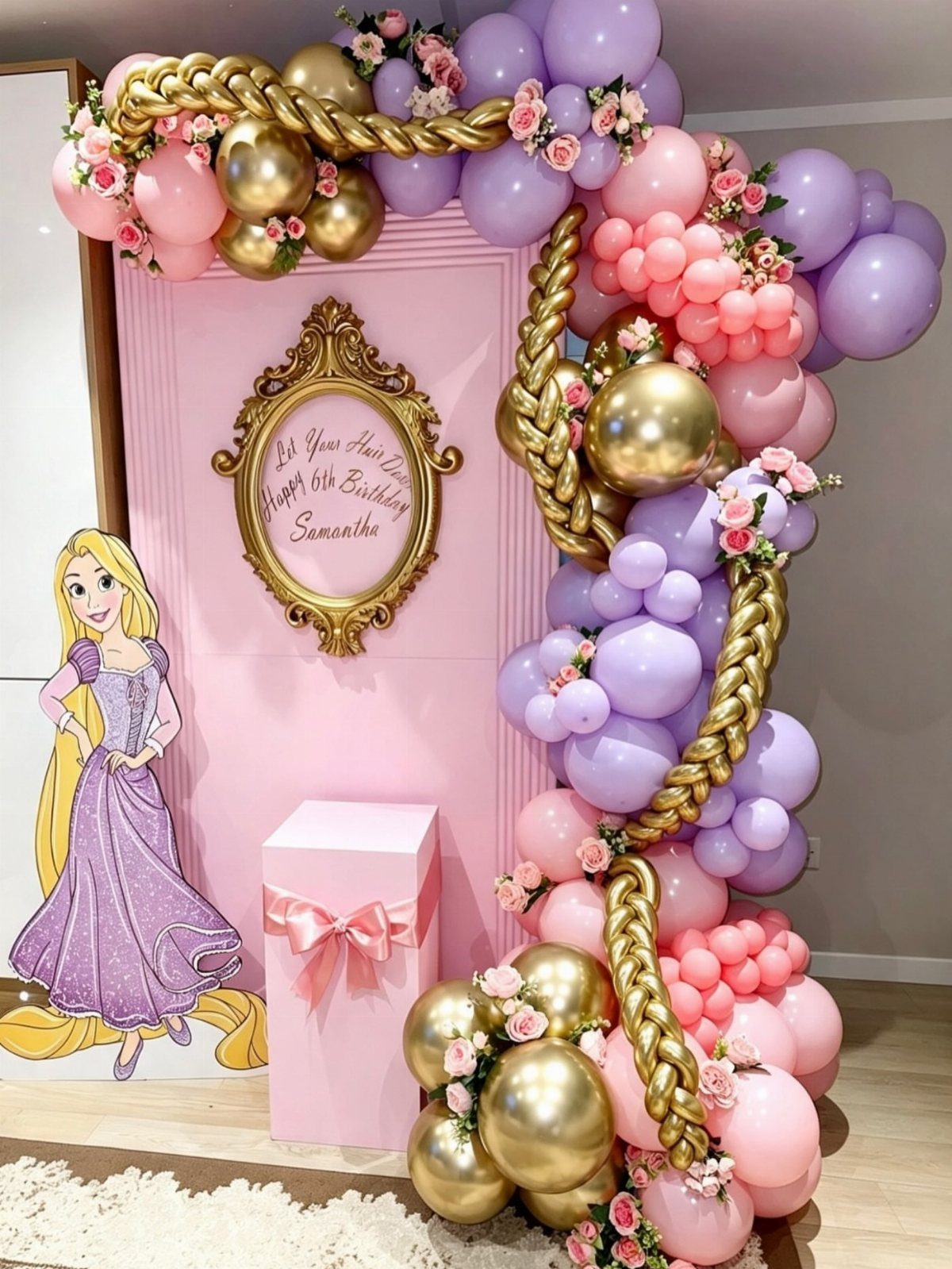 Pink birthday backdrop with Rapunzel cutout and purple, pink, and gold balloon arch.