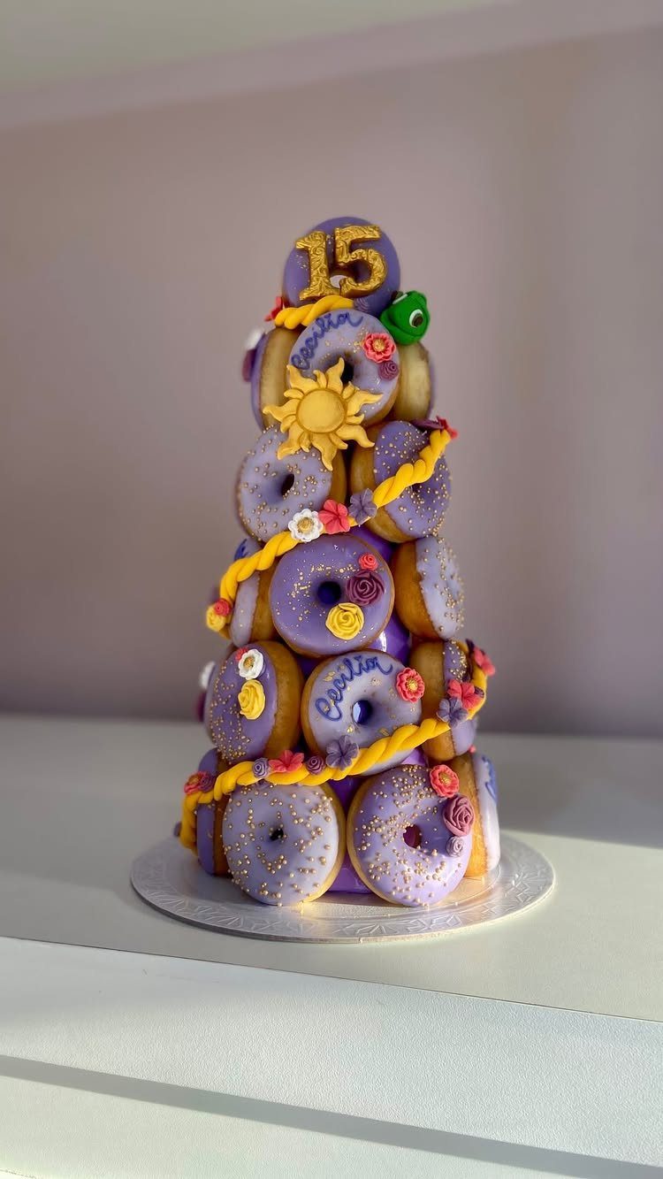 Purple donut tower decorated with a golden sun, braided rope, and number 15 topper.