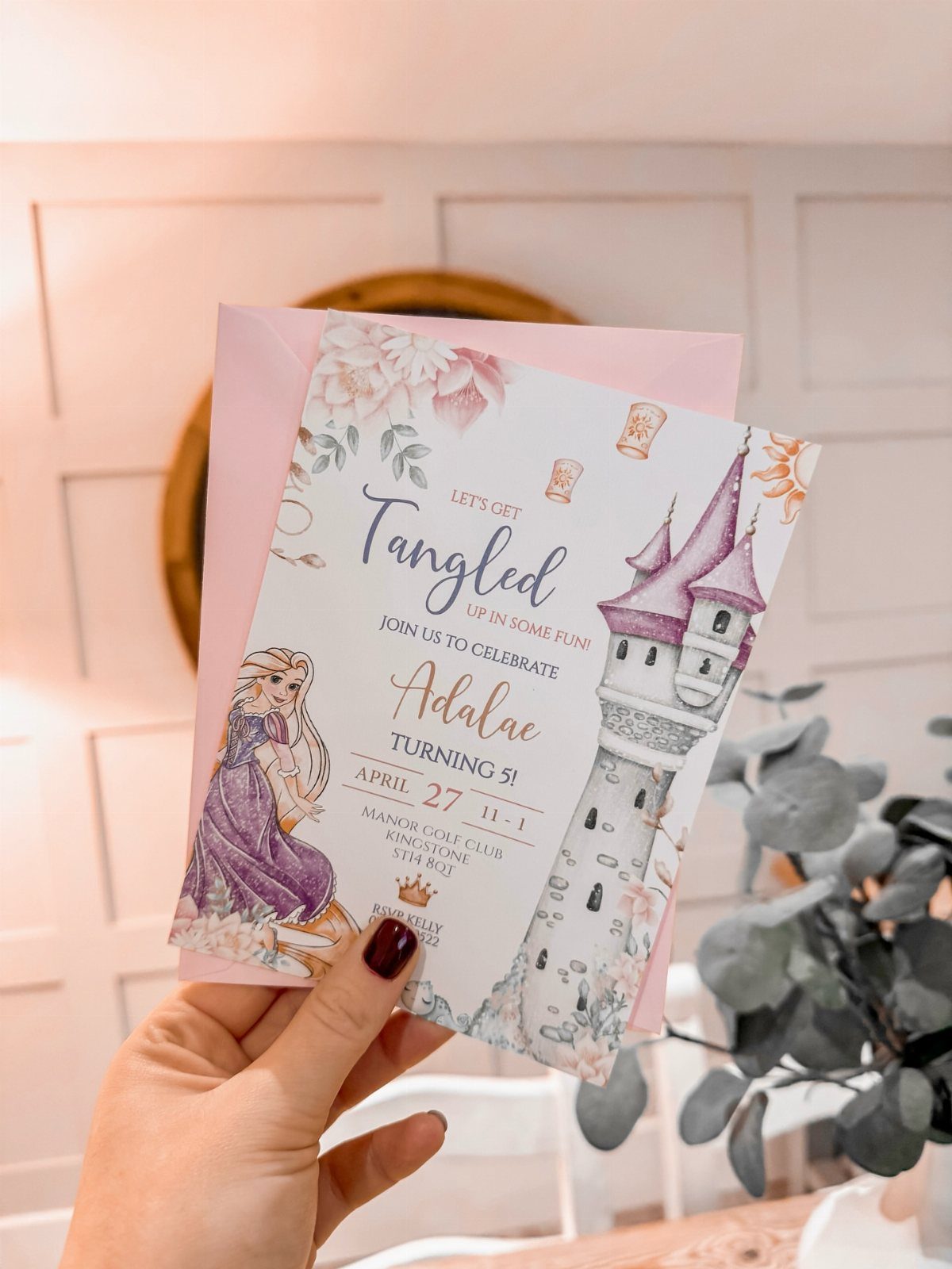 Tangled themed birthday invitation featuring Rapunzel and a tower held by a hand.
