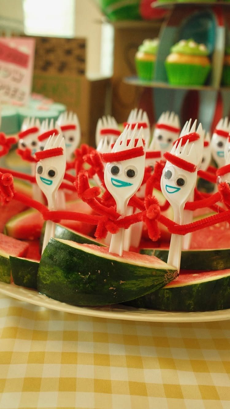Forky character forks stuck into watermelon slices on a yellow checkered tablecloth.
