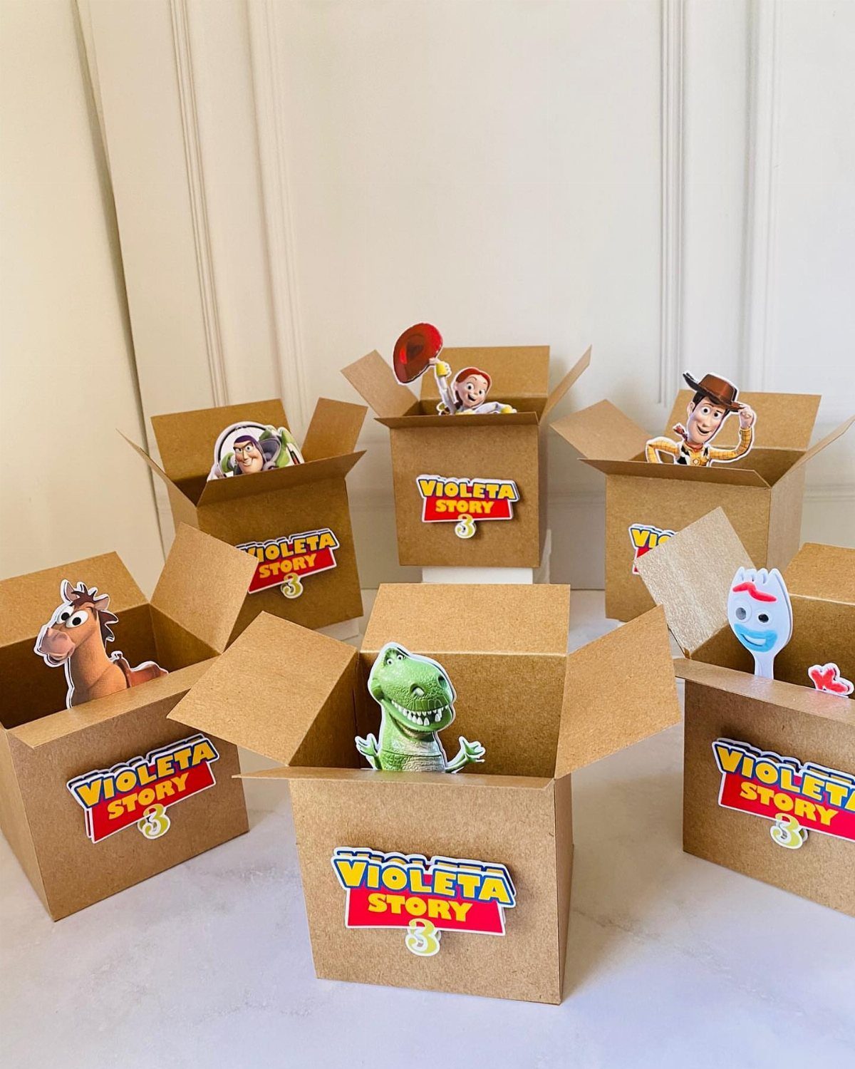 Brown cardboard gift boxes with Toy Story character cutouts and personalized labels.