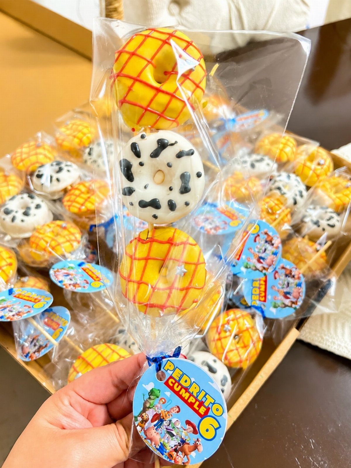 Toy Story themed donuts on sticks in plastic bags with character tags.
