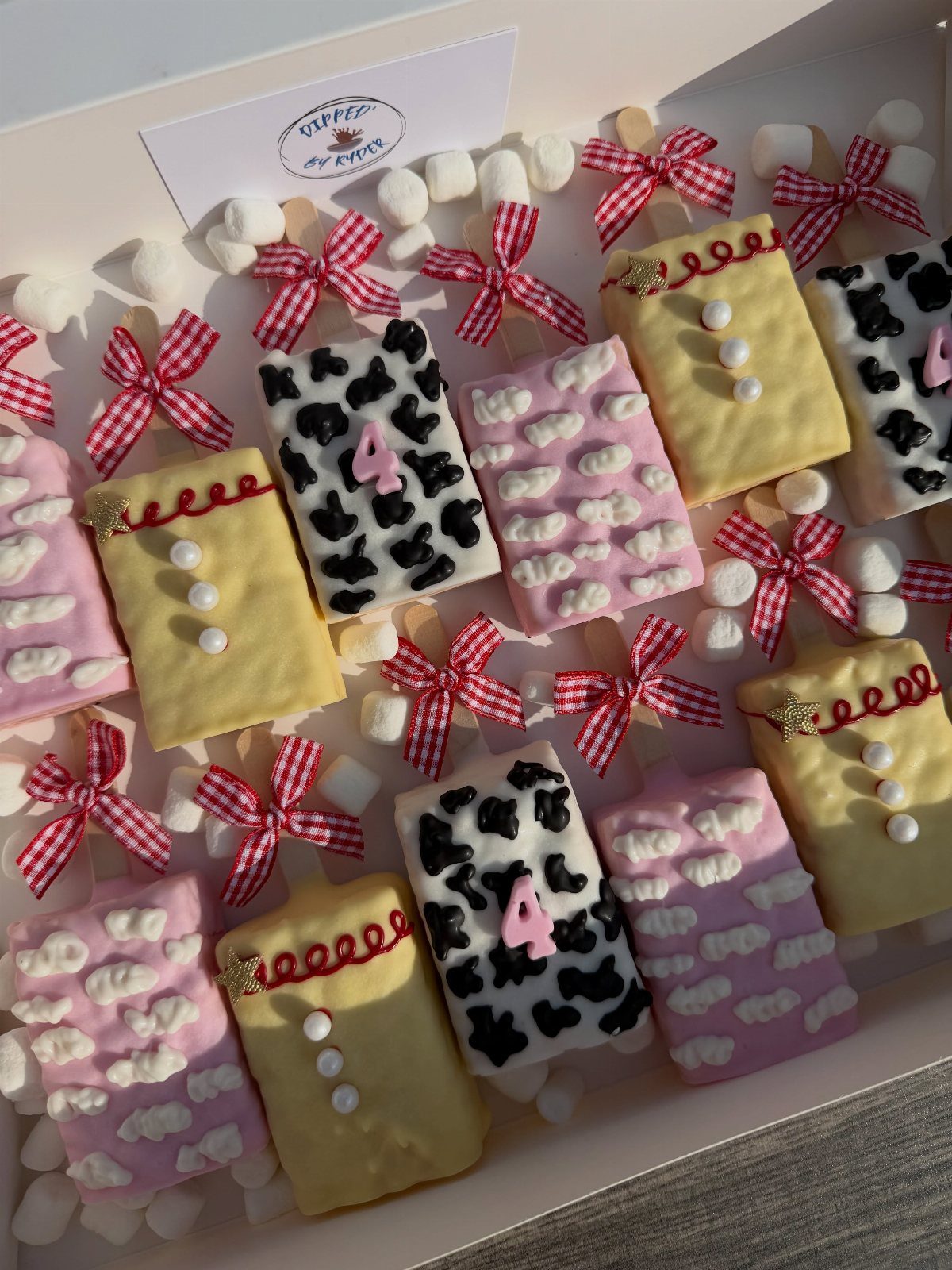 Themed chocolate treats with sheriff and cow print designs in a white box.