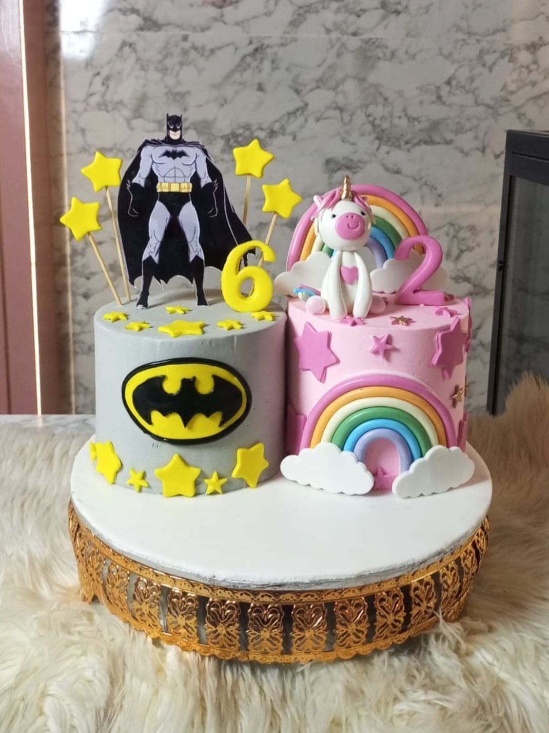 Split birthday cake featuring Batman on one side and a unicorn on the other.