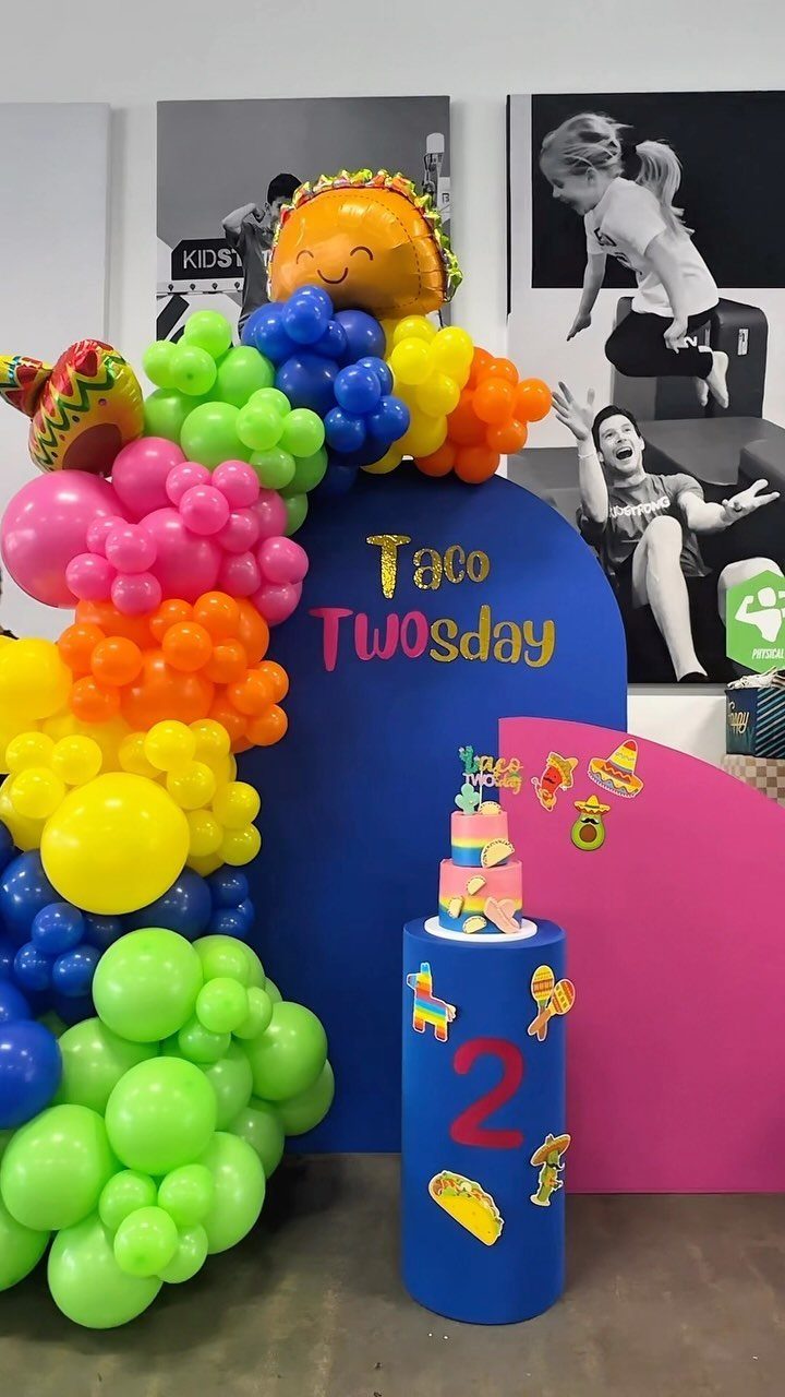 Taco Twosday party decorations with a colorful balloon arch and taco balloons.